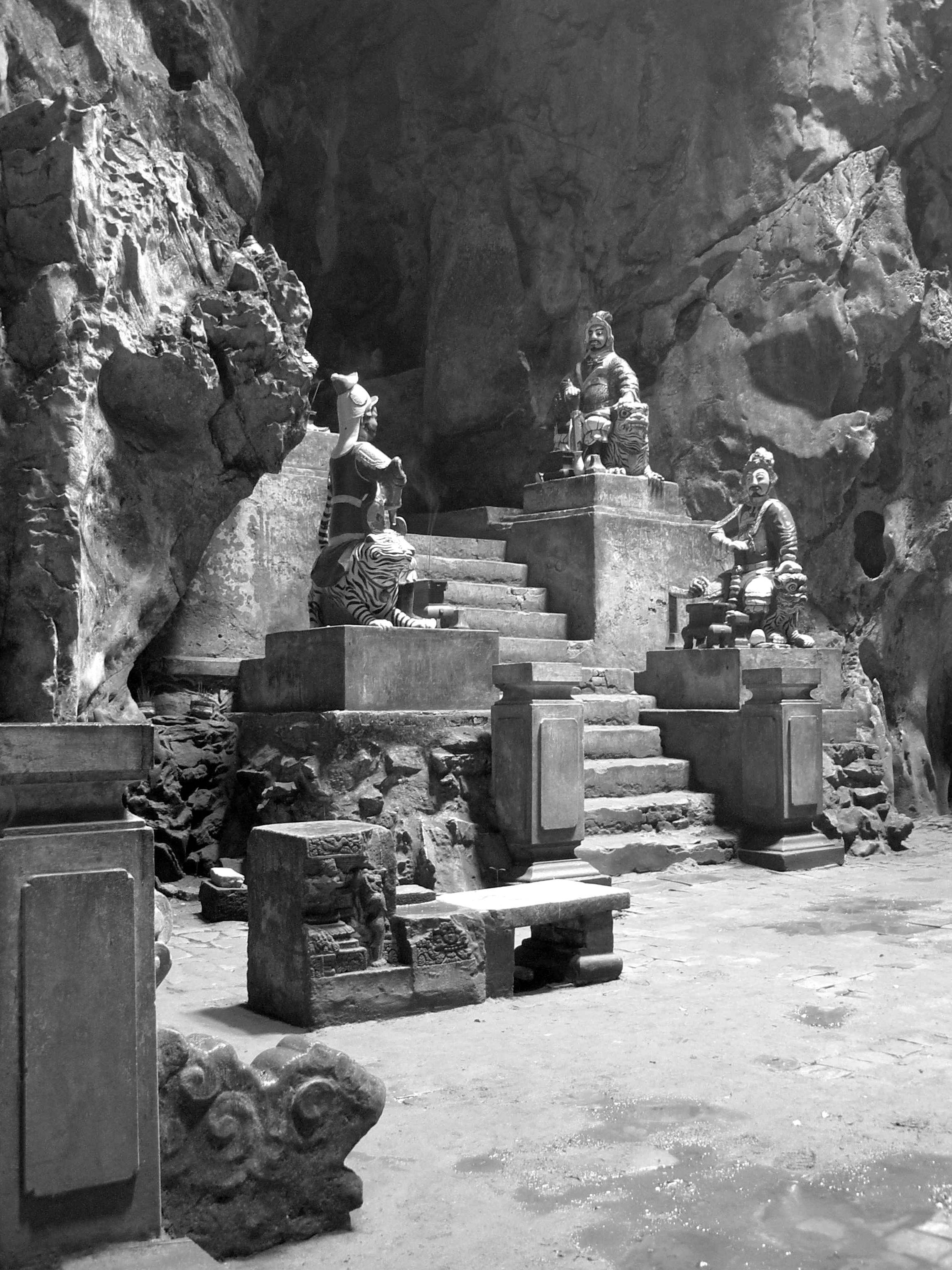 Guardian statues and stone steps inside one of the cave temples on Thủy Sơn